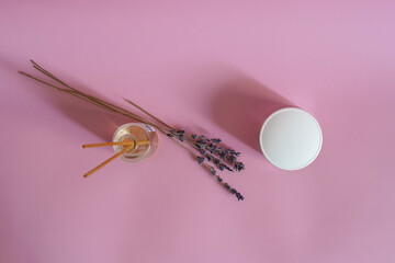 Empty glass jar for face cream moisturiser and aroma diffusor on pink background, skincare and cosmetic, beauty product