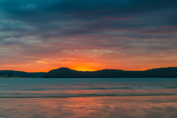 Fototapeta na wymiar Colourful cloud filled sunrise at the seaside