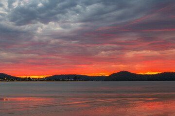 Fototapeta premium Colourful cloud filled sunrise at the seaside
