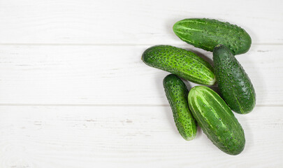 five cucumbers lies on a gray wooden surface. View from above