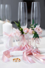 Rings and wedding details in pink style, which are on the table.