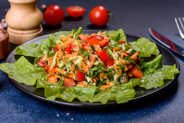 Plate of salad with vegetables and greens on a dark concrete table