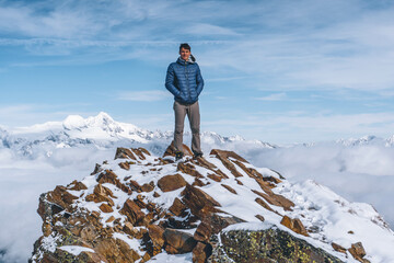 man on a snow covered peak in a mountain landscape