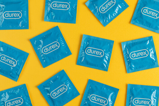 Lviv, Ukraine - August 02, 2022. Durex condoms on yellow background. Pattern, top view.