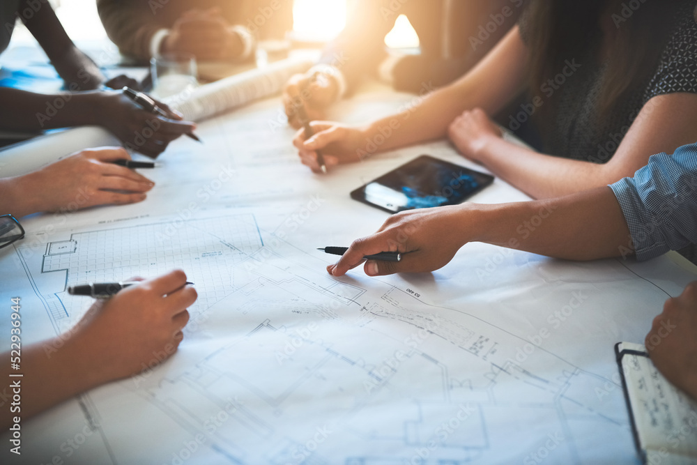 Poster architect working with a team or group, looking over plans or blueprints and talking about architect