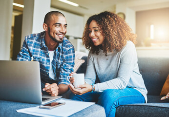 Home finance, savings and investment with a young couple working on a laptop in their living room. Man and woman calculating a household budget together while relaxing and drinking coffee on the sofa