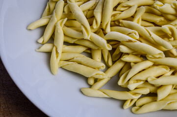 raw strozzapreti, specialties from northern Italy, fresh twisted pasta that cooks very quickly and is suitable for chunky sauces