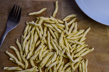 raw strozzapreti, specialties from northern Italy, fresh twisted pasta that cooks very quickly and is suitable for chunky sauces