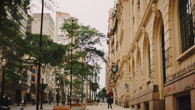 centre of sao paulo traveling out, sidewalk with passersby, slow motion