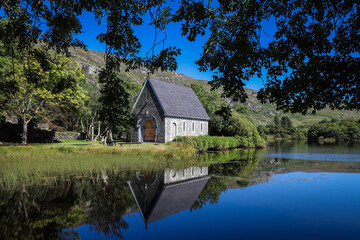 Fototapeta na wymiar Gougane Barra is a scenic valley and heritage site in the Shehy Mountains of County Cork, Ireland. It is at the source of the River Lee and includes a lake with an oratory built on a small island.