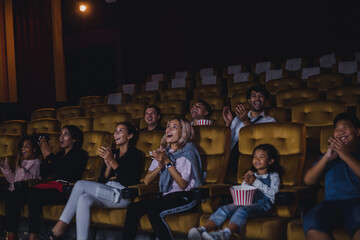 Young and adult audience groups enjoying the movie and bring food to eat while watching in the cinema.
