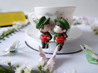 The cuteness and brightness of a cute doll with a cup of coffee in the morning that is sweet and refreshing.