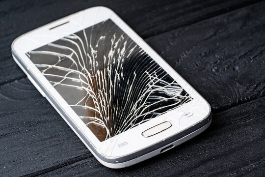 Crashed phone display on black background. Smartphone with broken galss.