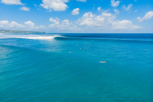 Aerial view of blue waves and surfers in Bali. Balangan beach