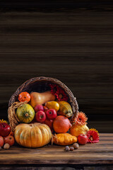 Obraz na płótnie Canvas Thanksgiving day background with empty copy space. Pumpkin harvest in wicker basket. Squash, orange vegetable autumn fruit, apples, and nuts on a wooden table. Halloween decoration fall design