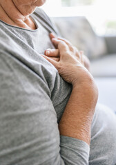 Elderly woman with heart pain holding her chest