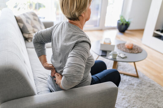 Elderly woman at home with back pain