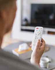 Senior woman with remote control watching tv