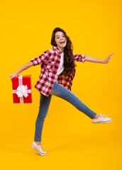 Amazed teenager. Child with gift present box on isolated background. Presents for birthday, Valentines day, New Year or Christmas. Excited teen girl.