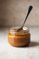 Homemade creamy caramel in a jar. Close up.