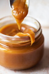 Homemade creamy caramel in a jar. Close up. - 522947586