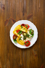 Top view of summer tomato salad with italian buffalo cheese and pesto on wood