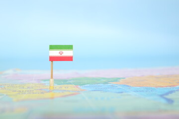 Selective focus of Iranian flag in world map. Iran country location and sovereignty concept.
