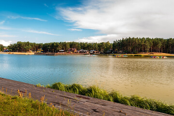 Wooden platform over the reservoir. Beaches in the light of the setting sun in the background. Krasnobród, Poland