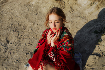 A beautiful girl in a traditional ethnic red dress posing outdoors.
