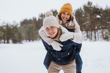 people, season, love and leisure concept - happy couple having fun in winter park