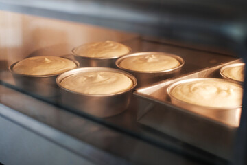 A fresh sponge and chiffon round cake baked in the oven with warm right. A homemade minimal cake in...