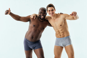 Fototapeta na wymiar two multiethnic men posing for a male edition body positive beauty set. Shirtless guys with different age, and body wearing boxers underwear