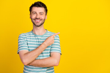 Portrait of young attractive smiling beaming guy pointing empty space good dentistry clinic isolated on yellow color background