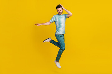 Fototapeta na wymiar Full size photo of cool guy jump wear t-shirt jeans shoes isolated on yellow color background
