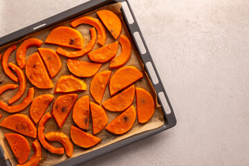 Chopped baked sweet butternut pumpkin on a baking sheet, top view