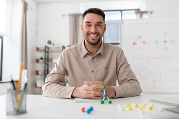 distance education, school and remote job concept - happy smiling male chemistry teacher with molecular model having online class at home office