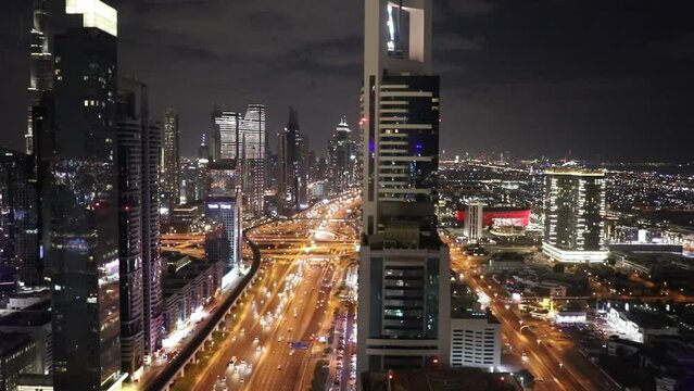 Aerial night illuminated city view Sheikh Zayed road skyline skyscrapers commercial condominiums suburbs vehicle transport highway metro UAE Dubai RED WEAPON. Time lapse