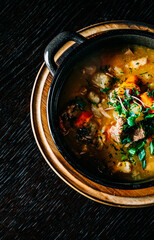 Pichelsteiner. meat soup with vegetables in bowl on wooden table background
