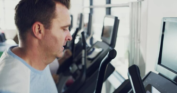 Male beginner jogging or running on treadmill, working on health and fitness in the gym. Normal person doing a workout, getting active and improving wellness. Man changing lifestyle and doing a detox