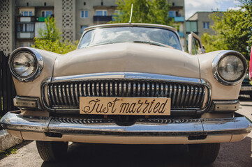 Fototapeta na wymiar Car with just married sign in a blackboard. Antique wedding car.