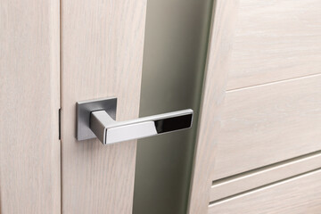 Close up of beautiful and stylish new metal door knob on modern interior door.