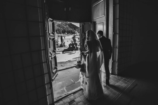Bride and groom go back exit from the church after wedding ceremony. Black and white photo.