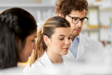 science, work and people concept - international group of scientists working in laboratory