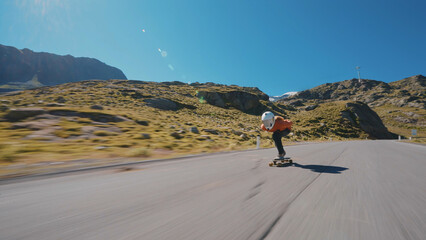 Cinematic downhill longboard session. Young woman skateboarding and making tricks between the...