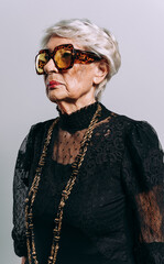 image of a beautiful and elegant old influencer woman. Cool grandmother posing in studio wearing...