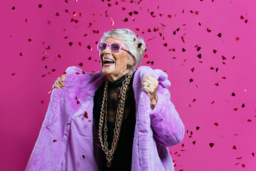 image of a beautiful and elegant old influencer woman. Cool grandmother posing in studio wearing fashionable clothes - obrazy, fototapety, plakaty