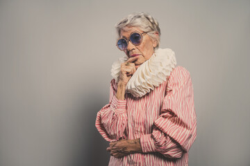 image of a beautiful and elegant old influencer woman. Cool grandmother posing in studio wearing...