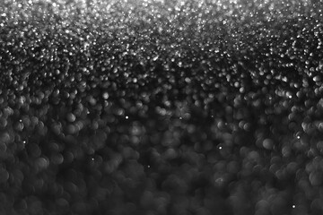 Gray black sparkling glitter bokeh background, christmas abstract defocused texture. Holiday...