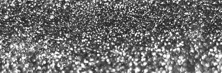 Gray silver sparkling glitter bokeh background, christmas abstract defocused texture. Holiday lights. Snowy shiny sparkle stars header. Wide screen wallpaper. Panoramic web banner with copy space
