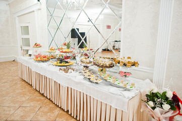 Beautiful wedding candy bar with sweets, fruits and food. Wedding banquet table
